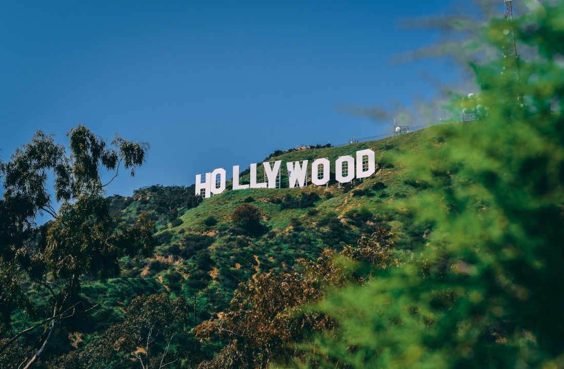A picture of the Hollywood Sign on green grassy hills by Paul Deetman