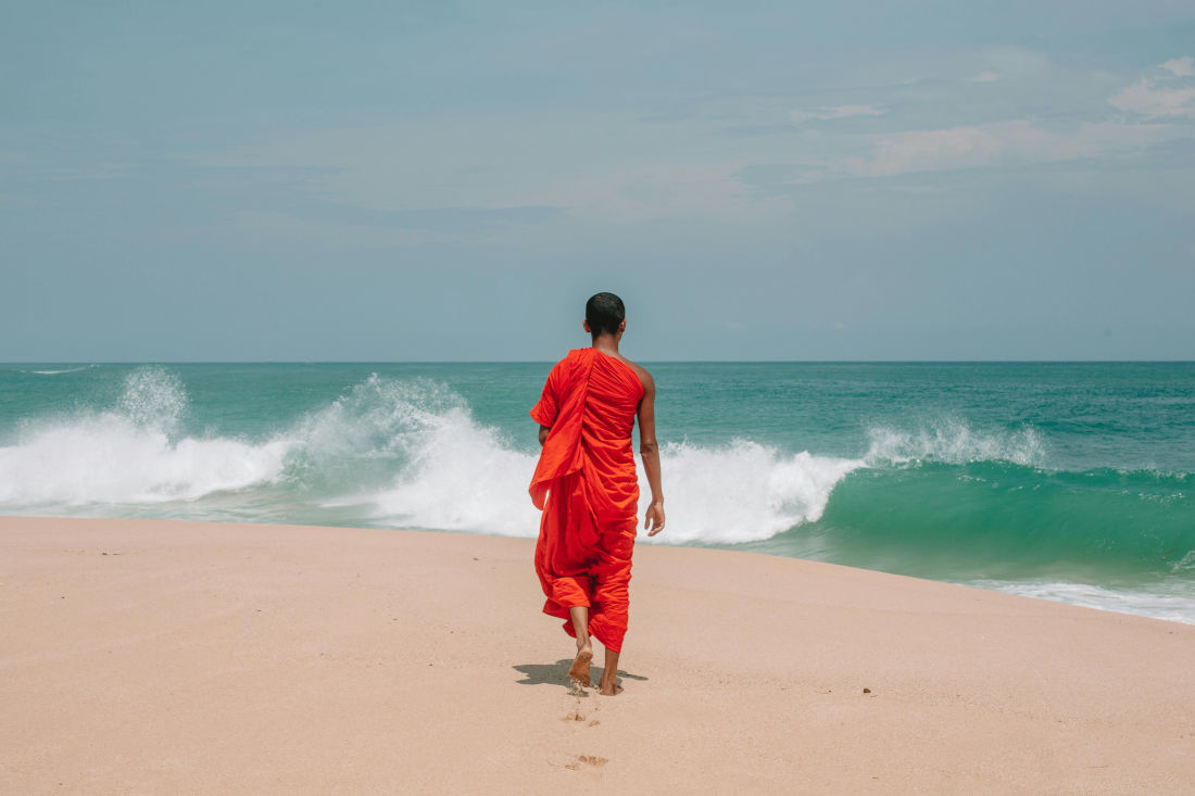 A monk walking along the ocean shore