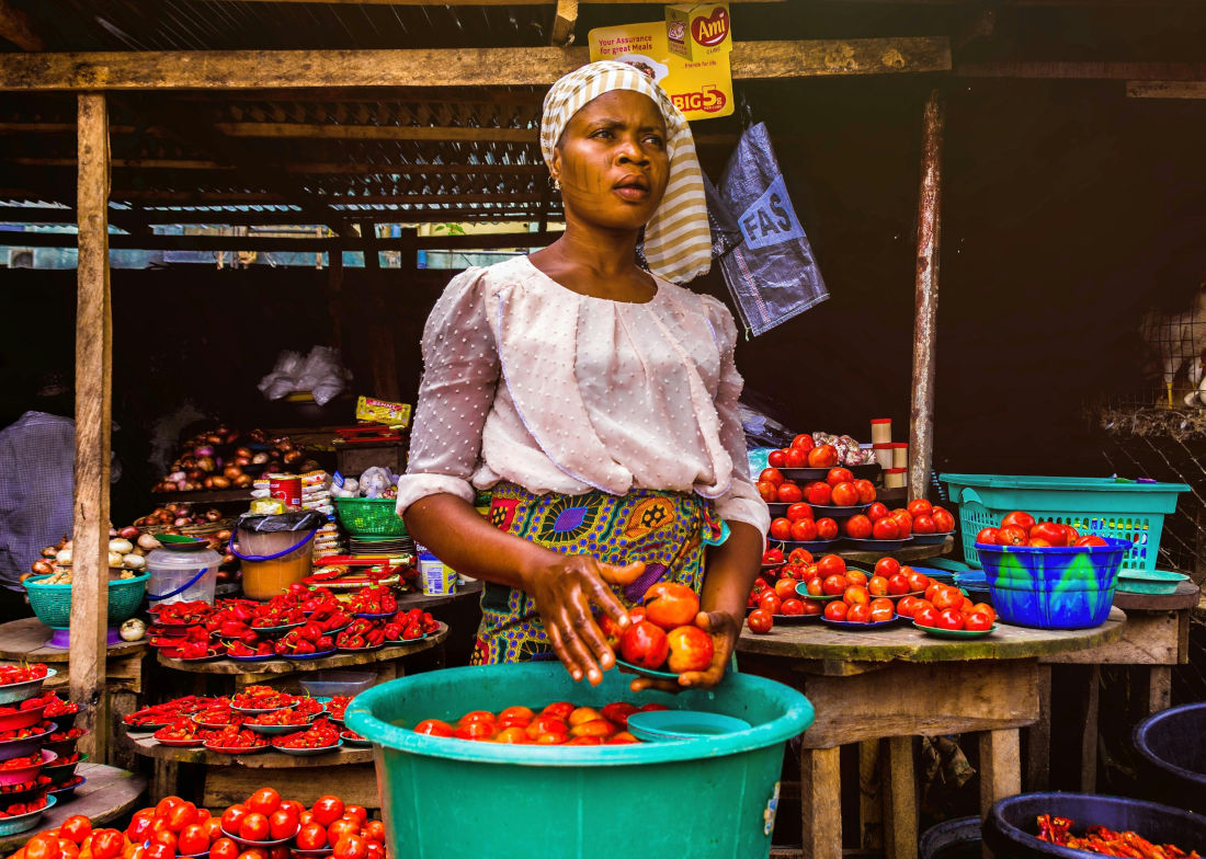 Woman cleaning tomatos on a market in Africa
